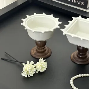 Vintage keramische schaal op hoge voet met kroonrand en elegante houten basis.