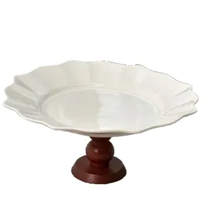 Elegant white ceramic footed dessert plate with vintage wooden base for home kitchen and party use.