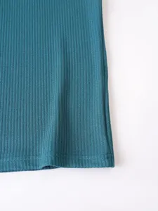 Detailansicht eines Herren Polohemdes mit feiner vertikaler Rippstrick Textur am unteren Saum.