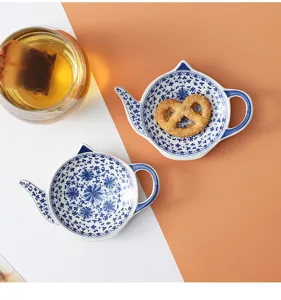 Ceramic teapot shaped tea bag dish detail, blue and white floral pattern for cute table decor.
