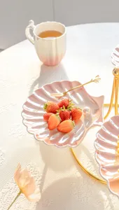 Detalle de plato postre concha cerámica, elegante soporte pastel rosa degradado té.
