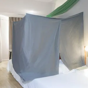 Detailansicht des grauen Bett-Privatsphäre-Zeltes im Hotelzimmer mit Stofftextur und kompletter Hülle.