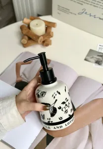 Ceramic soap dispenser bottle with chic flower bird pattern and pump for bathroom decor.
