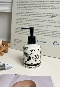 Ceramic soap dispenser bottle with elegant black and white floral bird pattern and pump.