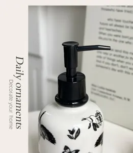 Ceramic soap dispenser detail, black and white floral pattern with pump, bathroom accessory.