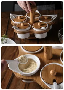 Close-up detail of the rotating ceramic spice jar set, featuring natural wooden tray and spoons.