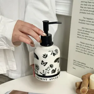 Ceramic soap dispenser with black and white floral pattern and pump for bathroom.