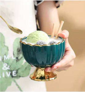 Detail view of the ceramic ice cream bowl with gold rim and elegant pedestal design.