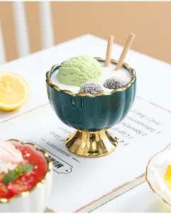 Ceramic high-footed ice cream cup detail shot, showing green bowl with golden rim and base.