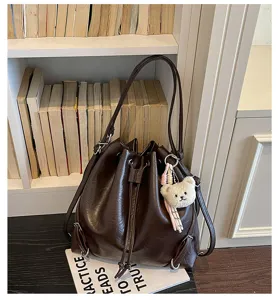 Bolso cubo retro de cuero PU marrón oscuro con lindo colgante de oso, gran mochila.