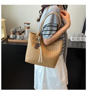 Detailed shot of the stylish woven tote bag in brown, featuring large capacity and chic charm.