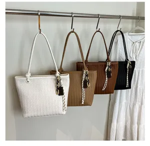 Chic woven tote bag with chocolate pendant, stylish large capacity shoulder bag for women.