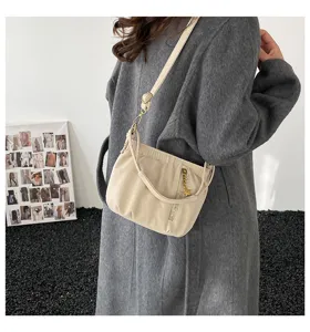 Detailed view of the chic neutral beige gathered crossbody bag with star charm and strap.