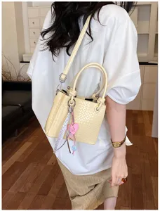 Stylish woven bucket bag with top handle and crossbody strap, trendy women's purse.