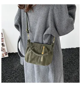 Detailed view of the dark green crossbody bag with ruched design and metal star charm.