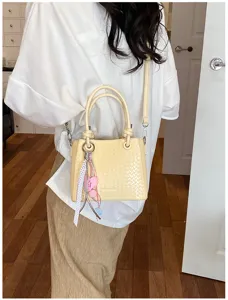 Chic woven bucket bag for women, stylish leather shoulder crossbody bag with cute charm pendant.