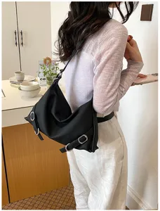 Élégant sac porté épaule hobo noir souple avec boucles pour femmes, chic et tendance.