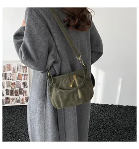 Detail shot of a chic olive green gathered shoulder bag with gold zipper and star pendant charm.