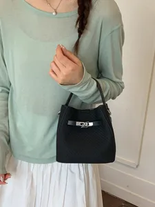 Stylish black bucket bag for women, commuter handbag with metal lock strap design for daily use.