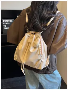 Vista detallada de la mochila de cuero crema con cordón para un estilo diario elegante.