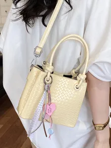 Trendy yellow woven bucket bag with elegant heart pendant for women stylish daily commuting use.