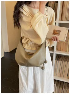 Chic leather underarm dumpling bag with zip and sphere pendant for women daily casual outfits.