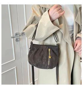 Stylish dark grey shoulder bag detail view, featuring soft leather and chic star charm pendant.