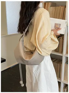 Casual minimalist slouchy shoulder dumpling bag in light gray color for everyday use.