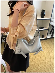 Vue détaillée du sac porté épaule gris-bleu montrant une boucle latérale et une texture fine.