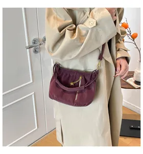 Chic pleated shoulder bag detail, burgundy faux leather with star charm and front zip pocket.