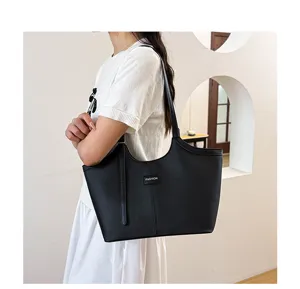 Black PU leather tote bag detail view, showing large capacity, minimalist design for daily commute.