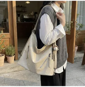 Casual commuter tote bag detail showing soft beige PU leather, zipper pockets and keychain.