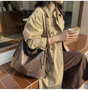 Vintage brown tote bag detail showing large capacity, soft leather material, and zipper accents.