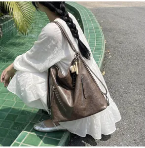Close-up detail of the vintage brown hobo shoulder bag, showcasing soft PU leather and zippers.