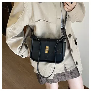 Detailed view of black leather crossbody bag, vintage messenger bag with metal lock.