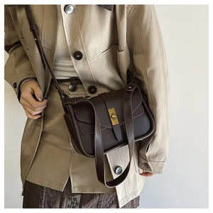 Detailed view of women's brown retro messenger bag with metal lock and soft leather.