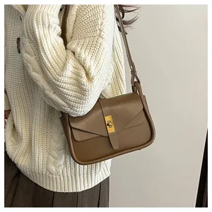 Brown leather shoulder bag detail shot, vintage messenger style with metal clasp closure.