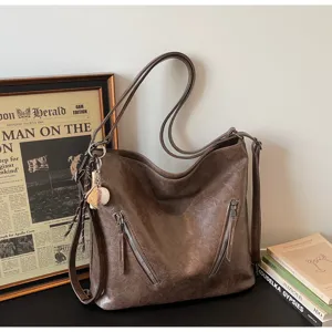 Brown PU leather commuter tote bag detail shot, featuring front zipper pockets and retro style.