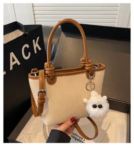 Stylish women's woven bucket bag with brown leather trim, perfect for spring and summer chic looks.