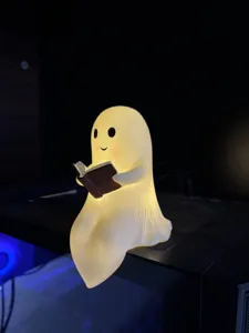 Primer plano de una lámpara de fantasma leyendo un libro para decoración de Halloween.