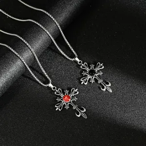 Detail view of gothic punk cross pendants with red and black gemstones on silver chains
