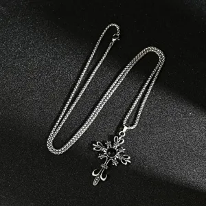 Macro view of gothic punk cross necklace with black gemstone and vintage silver chain