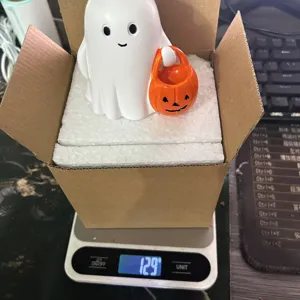 Detail view showing the weight of a cute white ghost resin figurine for Halloween