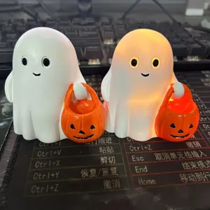Detailed view of cute Halloween ghost figurines featuring warm LED glow and orange pumpkin buckets