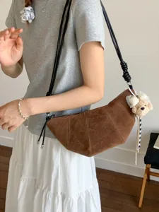 Retro brown suede croissant bag for women, chic crossbody dumpling bag with cute bear pendant.