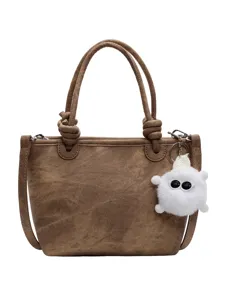 Brown textured canvas tote bag with knotted handles and cute white plush charm for women.