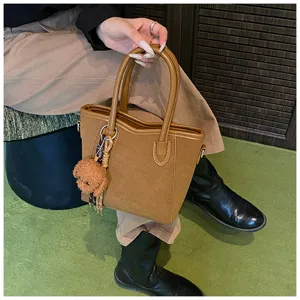 Modische braune Damen Handtasche mit niedlichem Plüschhund Anhänger und stabilem Tragegriff.