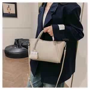 Detailed view of beige leather handbag with lock charm, casual daily commute style accessory.