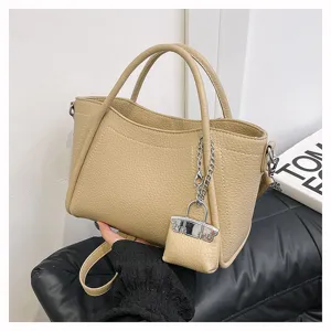 Detailed view of the beige pebbled leather tote bag with silver hardware and lock charm.