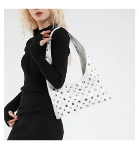 Close-up of the white leather shoulder bag featuring stylish metal studs and sleek underarm design.